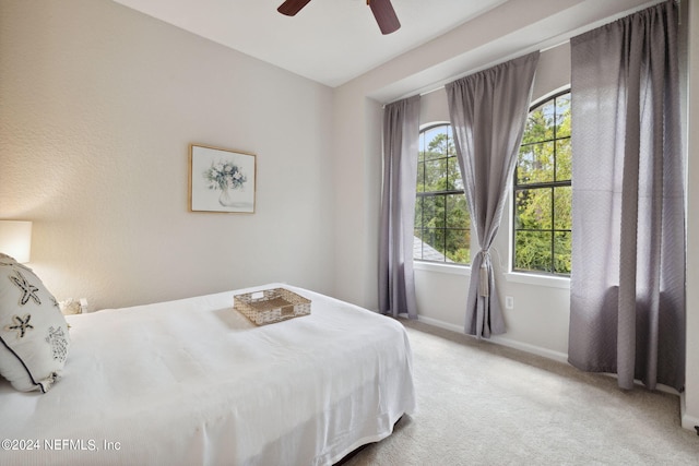 bedroom featuring a ceiling fan, light carpet, and baseboards