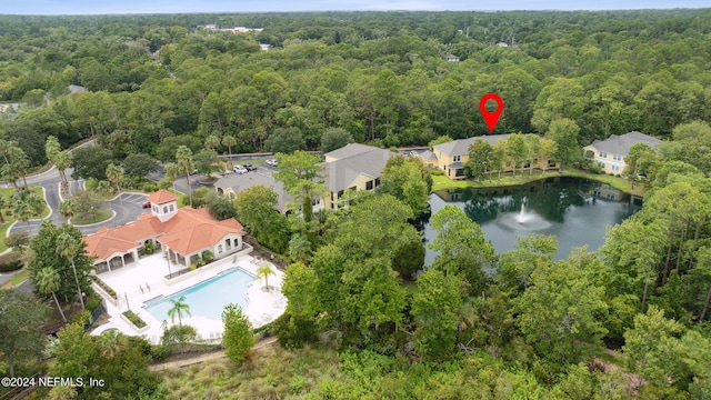 drone / aerial view featuring a water view, a residential view, and a wooded view