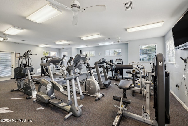 exercise room featuring a ceiling fan, visible vents, and baseboards