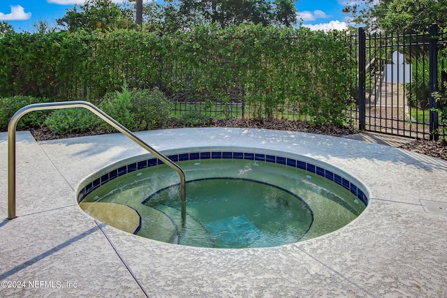 view of pool featuring fence and a community hot tub