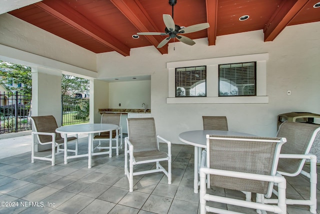 view of patio featuring outdoor dining area, ceiling fan, and fence