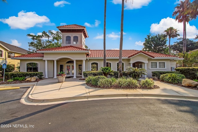 view of front of house featuring stucco siding, a tile roof, and french doors