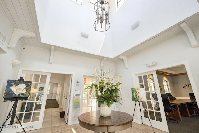 dining area with french doors, light tile patterned flooring, and a towering ceiling