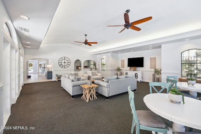 living area featuring arched walkways, dark colored carpet, recessed lighting, visible vents, and vaulted ceiling