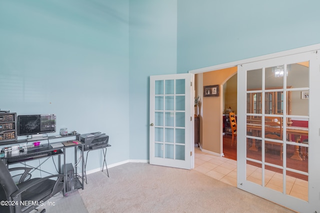 carpeted office space featuring french doors and a towering ceiling