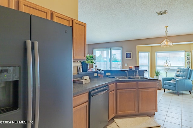 kitchen with a notable chandelier, stainless steel appliances, sink, and light tile patterned floors