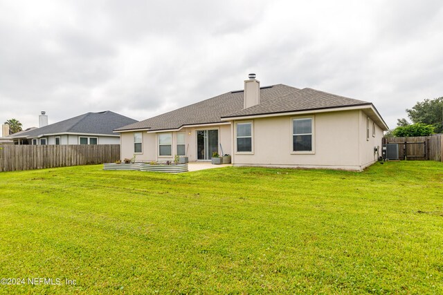 rear view of house with a lawn, a patio area, and central air condition unit