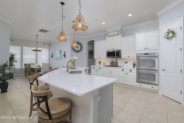 kitchen with light countertops, stainless steel appliances, a sink, and light tile patterned flooring