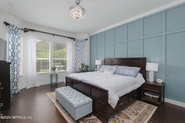 bedroom with a decorative wall, an inviting chandelier, dark wood-type flooring, ornamental molding, and baseboards