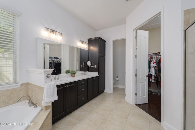 full bath featuring a sink, a spacious closet, a bath, tile patterned floors, and double vanity