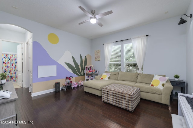 living room with arched walkways, ceiling fan, baseboards, and wood finished floors