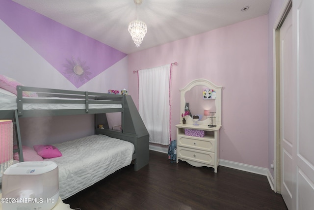 bedroom featuring a chandelier, lofted ceiling, baseboards, and wood finished floors