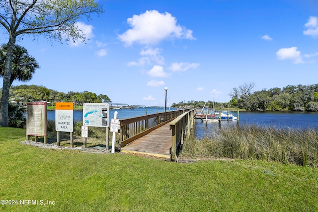 dock area featuring a lawn and a water view