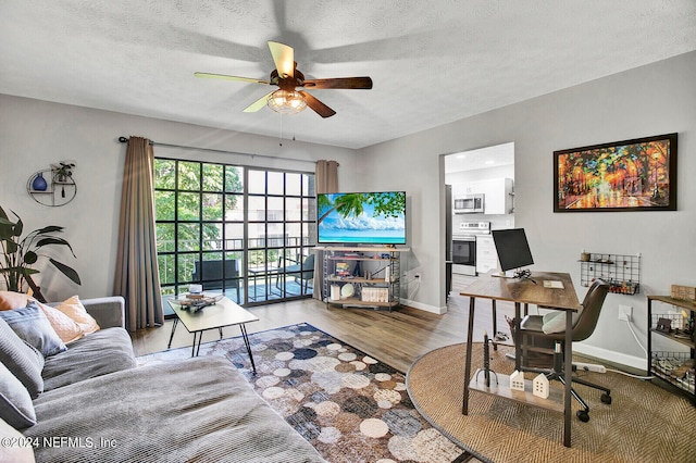 living room with light hardwood / wood-style floors, a textured ceiling, and ceiling fan