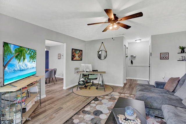 living room featuring light hardwood / wood-style floors and ceiling fan