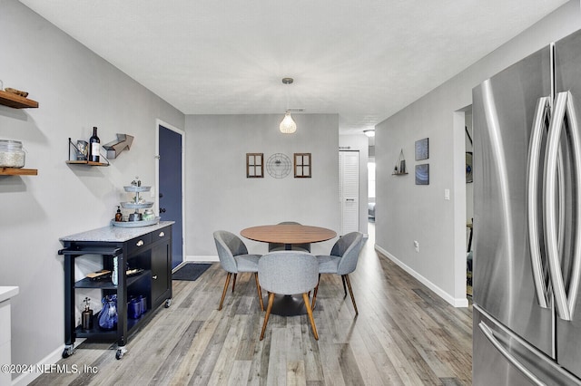 dining space with wood-type flooring