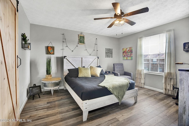 bedroom with ceiling fan, a textured ceiling, and wood-type flooring