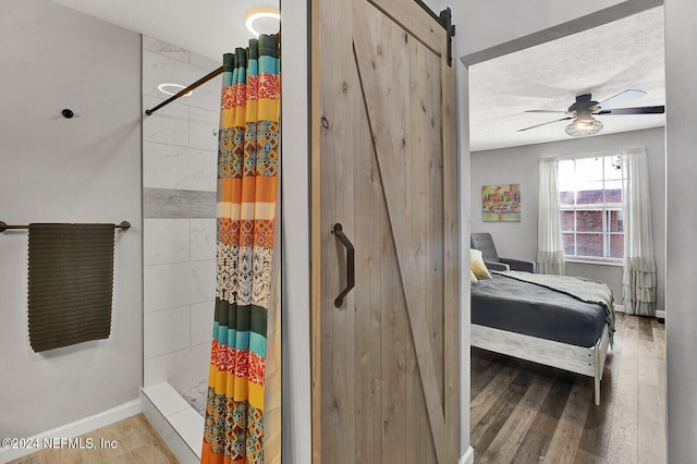 bathroom featuring a textured ceiling, ceiling fan, a shower with shower curtain, and wood-type flooring