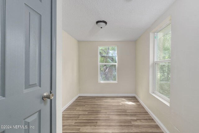 spare room with a textured ceiling and hardwood / wood-style floors