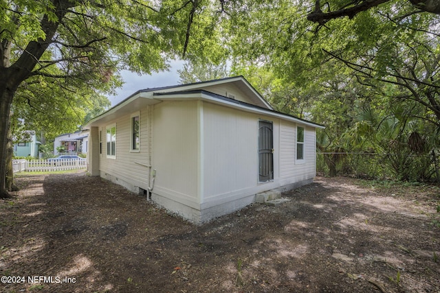 view of side of property featuring crawl space and fence