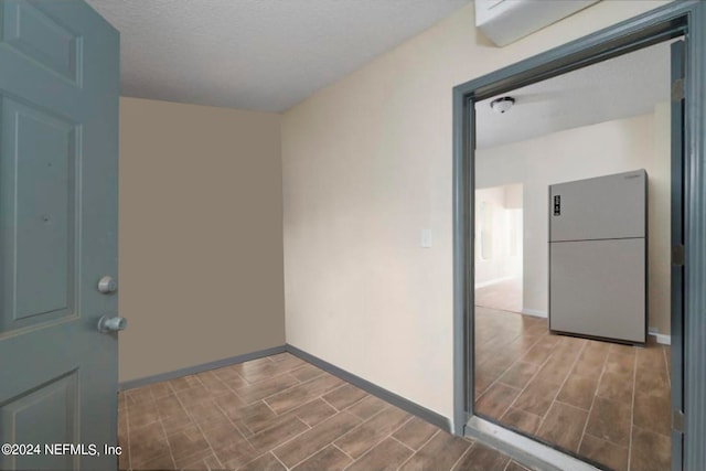 interior space with a textured ceiling and wood-type flooring