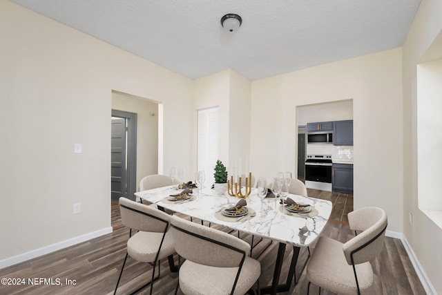 dining area with a textured ceiling and dark hardwood / wood-style floors