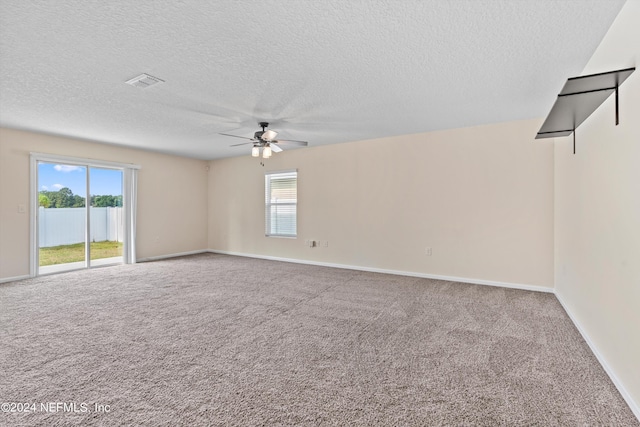 empty room featuring ceiling fan, visible vents, carpet, and plenty of natural light