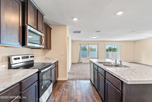 kitchen with dark brown cabinetry, dark carpet, sink, a textured ceiling, and stainless steel appliances