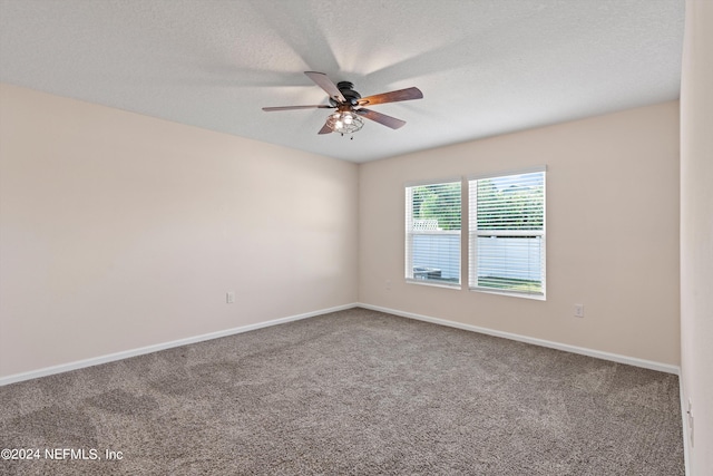 carpeted empty room featuring baseboards, ceiling fan, and a textured ceiling