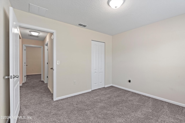 unfurnished bedroom featuring carpet, a closet, and a textured ceiling