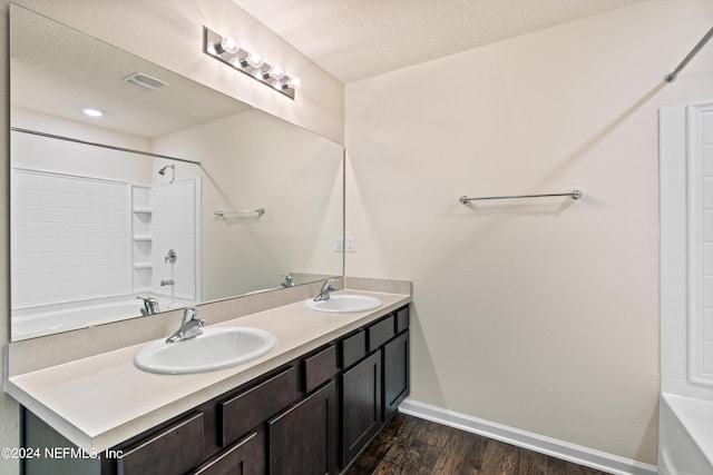 bathroom featuring baseboards, visible vents, a sink, and wood finished floors