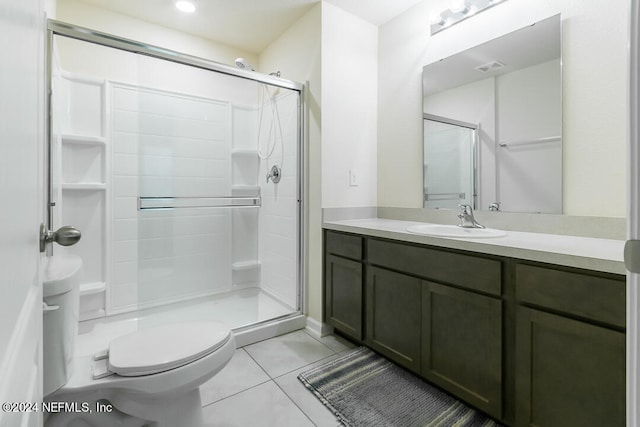 bathroom featuring toilet, tile patterned floors, vanity, and an enclosed shower