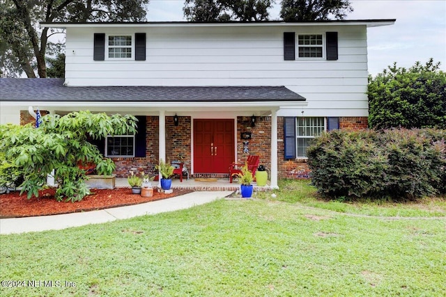 view of front of home with a front yard and a porch