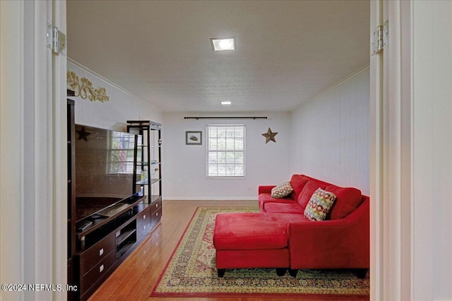 living room with ornamental molding and wood finished floors