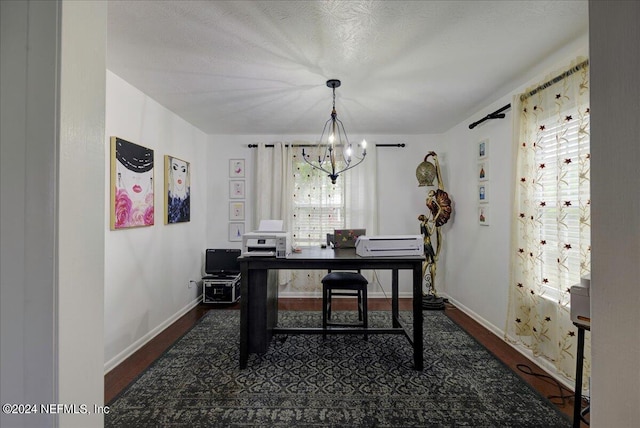 office area with a notable chandelier, a textured ceiling, baseboards, and wood finished floors