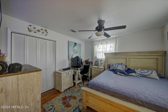 bedroom with visible vents, a ceiling fan, wood finished floors, a textured ceiling, and a closet