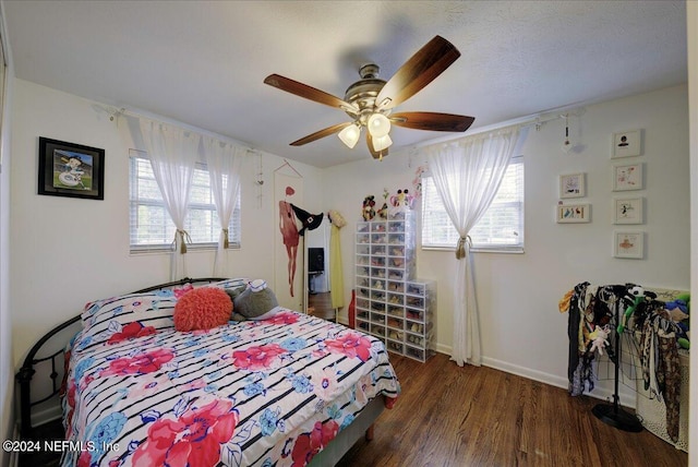 bedroom featuring a ceiling fan, baseboards, and wood finished floors