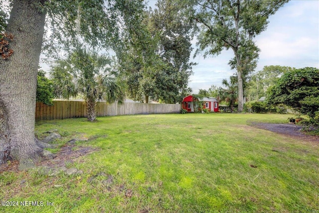 view of yard with fence private yard, a shed, and an outdoor structure