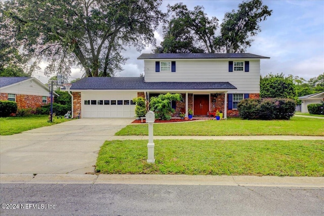 traditional-style home with a garage, concrete driveway, brick siding, and a front yard