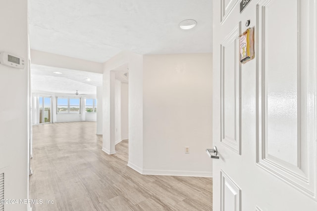 hallway with light hardwood / wood-style floors