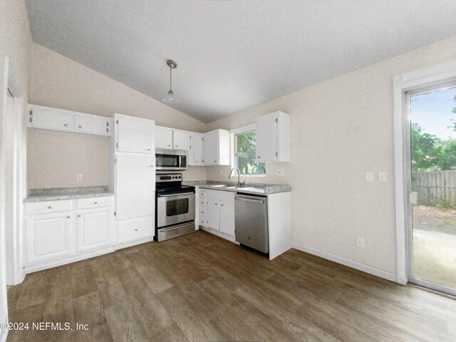 kitchen with dark hardwood / wood-style flooring, appliances with stainless steel finishes, white cabinetry, sink, and vaulted ceiling