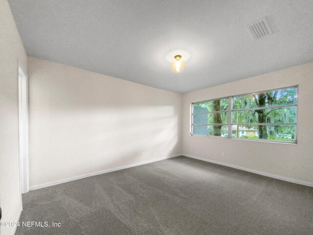 carpeted empty room featuring a textured ceiling