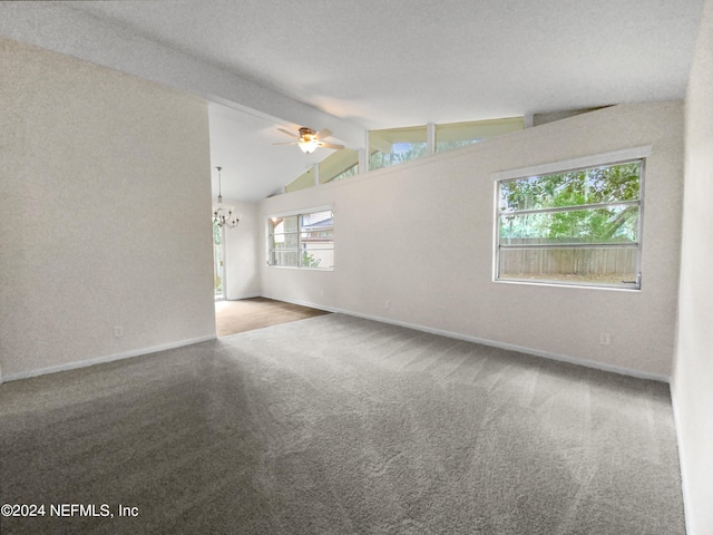 carpeted spare room with a textured ceiling, lofted ceiling with beams, and ceiling fan with notable chandelier