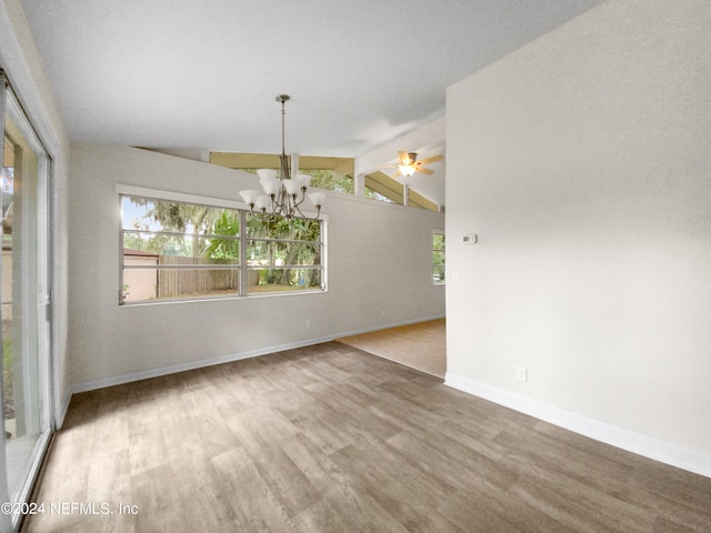 spare room with vaulted ceiling with beams, ceiling fan with notable chandelier, and hardwood / wood-style floors