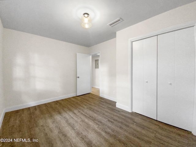 unfurnished bedroom with a closet and wood-type flooring