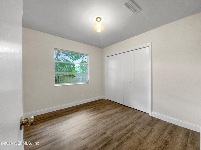 unfurnished bedroom featuring a closet and hardwood / wood-style flooring