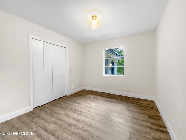 unfurnished bedroom with a closet and wood-type flooring