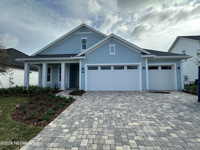 view of front of property featuring an attached garage and decorative driveway