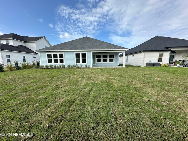 rear view of property with a yard, central AC unit, and a patio