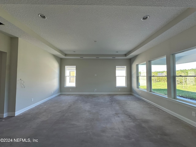 empty room featuring a textured ceiling and a wealth of natural light